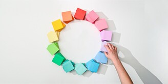 Mano formando círculo con bloques de notas post-it en varios colores
